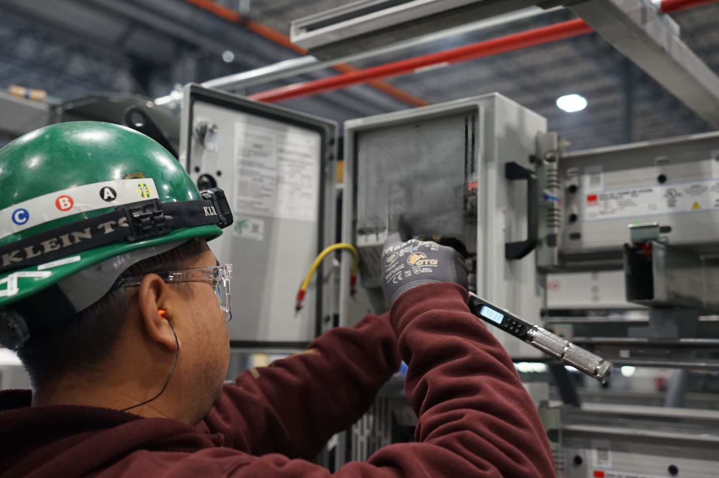 Cumulus user torquing bolts on an electrical panel while following a digital work instruction on a tablet